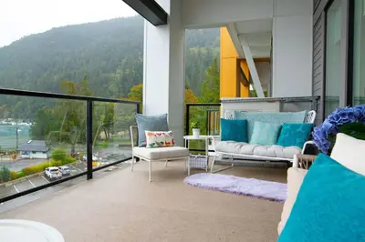 a living room with a view of a mountain at The Luna, New Penthouse w Patio, Lake and Mtn Views in Harrison Hot Springs
