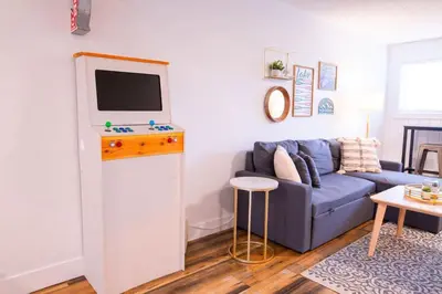 a living room with a blue couch and a flat screen tv at Harrison Lake Retreat, Studio Suite in Harrison Hot Springs