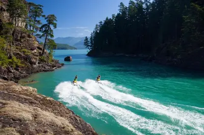 two people are riding motorcycles in a river at Echo Beach, 2 Bed, Lake View and Walkable to Beach in Harrison Hot Springs