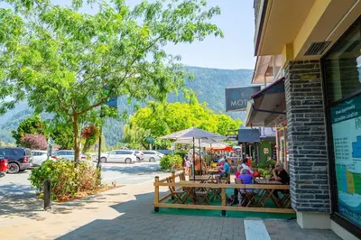 a group of people sitting at a table on a street at Echo Beach, 2 Bed, Lake View and Walkable to Beach in Harrison Hot Springs