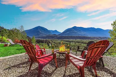 a group of chairs sitting around a table with a fire at EmeraldRidge Retreat - 180 Degree Amazing View & Firepit & BBQ in Chilliwack
