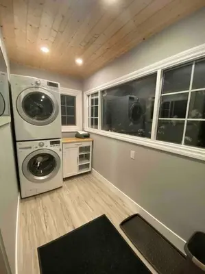 a laundry room with a washer and dryer and windows at Walk to the beaches and the restaurants downtown! in Kelowna
