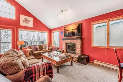 a living room with red walls and a fireplace at Fresh Tracks Retreat - Ski In Out Mtn View & Private Hot Tub in Big White