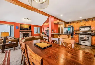 a kitchen and living room with a wooden table at Fresh Tracks Retreat - Ski In Out Mtn View & Private Hot Tub in Big White