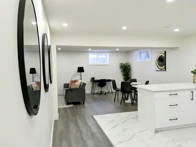 a kitchen and living room with a table and chairs at A Slice of Heaven in Chestermere in Calgary