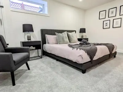 a bedroom with a bed and a chair at A Slice of Heaven in Chestermere in Calgary