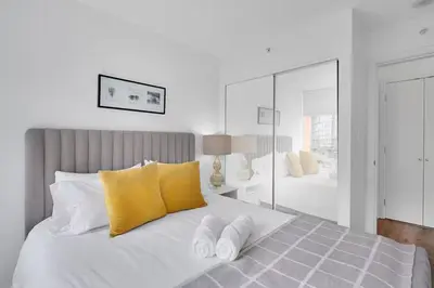 a bedroom with a white bed with yellow pillows at Stylish Condo in Downtown in Vancouver