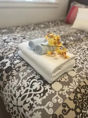 a pile of towels sitting on top of a bed at Two Bedrooms- A Warm House in Vancouver