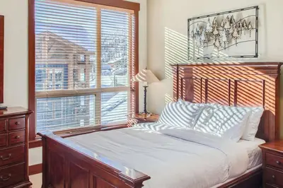 a bedroom with a bed and a large window at Stonegate Resort Unit A403 in Kelowna