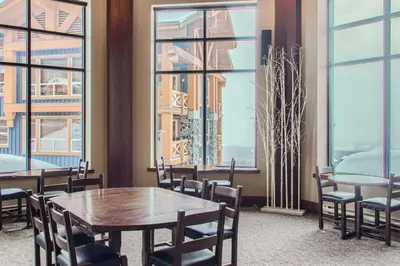 a dining room with tables and chairs and windows at Stonegate Resort Unit A403 in Kelowna