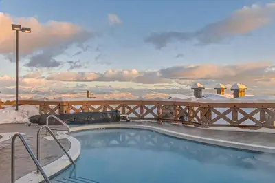 a swimming pool with a view of the snow covered mountains at Stonegate Resort Unit A403 in Kelowna