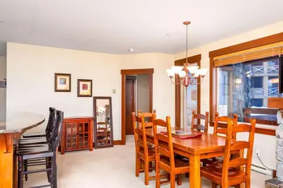 a dining room with a wooden table and chairs at Stonegate Resort Unit A104 in Big White