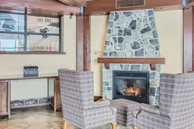 a living room with two chairs and a fireplace at Stonegate Resort Unit A104 in Big White