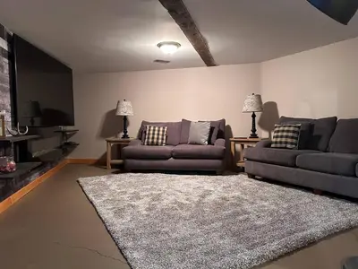 a living room with two couches and a rug at Ryders Lodge, Log Home in Edgewater, BC in Radium Hot Springs