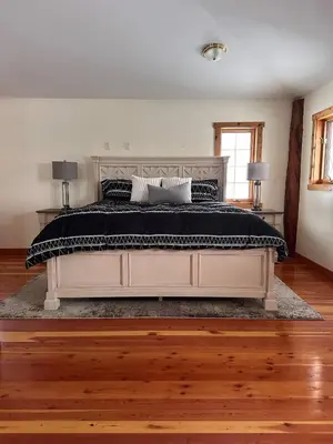 a bedroom with a large bed with a black comforter at Ryders Lodge, Log Home in Edgewater, BC in Radium Hot Springs
