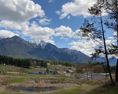a view of a mountain range from a field at Ryders Lodge, Log Home in Edgewater, BC in Radium Hot Springs