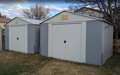 a couple of white garage buildings in a yard at Hillcrest Hideaway: Spacious Mountain View Oasis in Hillcrest Mines