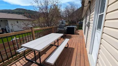 a picnic bench on a deck on a house at Hillcrest Hideaway: Spacious Mountain View Oasis in Hillcrest Mines