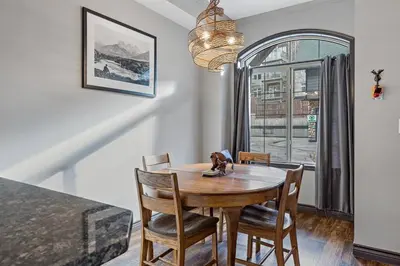 a dining room with a table and chairs and a window at Relaxing Mountain Getaway at Mystic Springs in Canmore