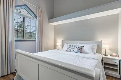 a white bedroom with a large bed and a window at Relaxing Mountain Getaway at Mystic Springs in Canmore