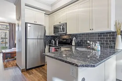 a kitchen with a refrigerator and a counter top at Relaxing Mountain Getaway at Mystic Springs in Canmore