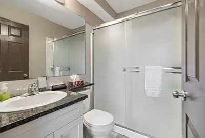 a bathroom with a toilet and a sink and a shower at Relaxing Mountain Getaway at Mystic Springs in Canmore