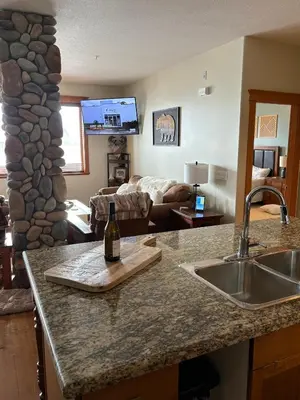 a kitchen with a counter top with a bottle of wine at Gone Ski 'Inn in Big White