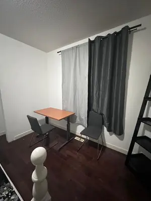 a table and chairs in a room with a window at Sam Estates in Calgary