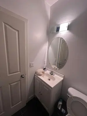 a white bathroom with a sink and a mirror at Sam Estates in Calgary