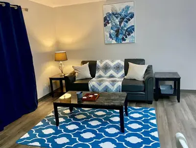 a living room with a couch and a table at All private 2 BRoom w 2 QUEEN BEDS-1 BTHRM-FREE PARKING-FAST WI-FI-CENTRAL LOCATION in Grande Prairie