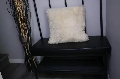 a black chair with a white pillow on it at Lovely 2Bd 1Bth suite Free pking separated HVAC in Calgary