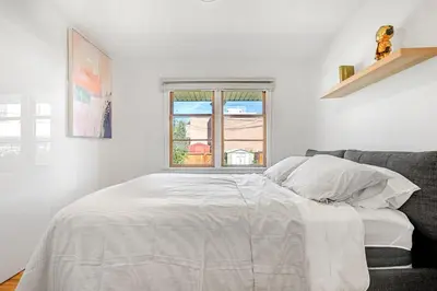 a white bedroom with a bed and a window at 3bd Luxury Home, Steps to Calgary DT, River, Hospital in Calgary