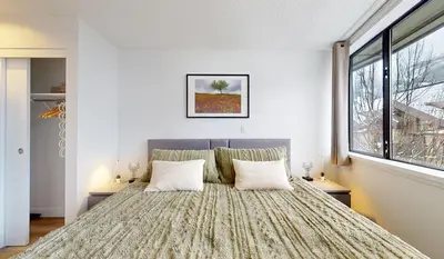 a bedroom with a large bed with two pillows at Whistler village central stay! in Whistler