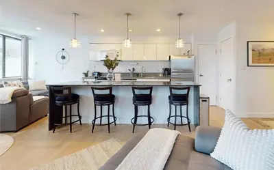 a kitchen and living room with a bar with stools at Whistler village central stay! in Whistler