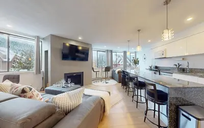 a living room with a couch and a kitchen at Whistler village central stay! in Whistler