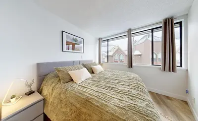 a bedroom with a bed and a large window at Whistler village central stay! in Whistler