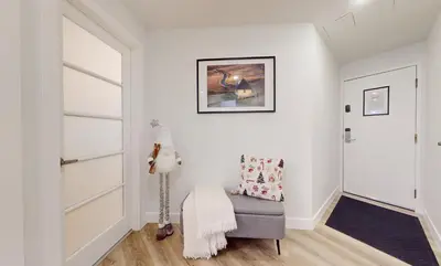 a living room with white walls and a gray chair at Whistler village central stay! in Whistler
