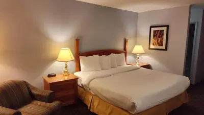 a hotel room with a bed and a chair at Metro Inn in Calgary