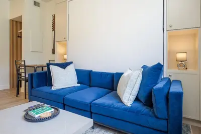a blue couch in a living room with a table at Newly Renovated KING BED STUDIO in the Village in Whistler