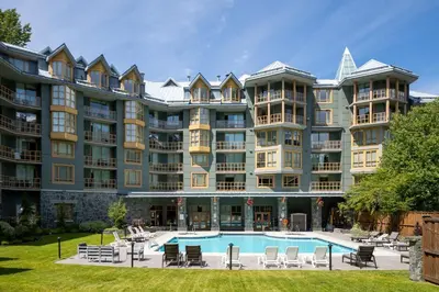 a large apartment building with a swimming pool at Newly Renovated KING BED STUDIO in the Village in Whistler