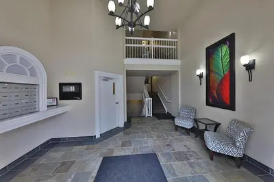 a hallway with two chairs and a painting on the wall at Ice District 2 Kings Underground Park Patio in Edmonton