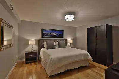 a bedroom with a bed and a tv on the wall at Ice District 2 Kings Underground Park Patio in Edmonton
