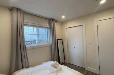 a bedroom with a bed and a large window at Modern Spacious 1BR minutes away from Main St in Vancouver