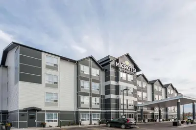 a hotel with a car parked in front of it at Microtel Inn & Suites by Wyndham Fort Saint John in Fort Saint John
