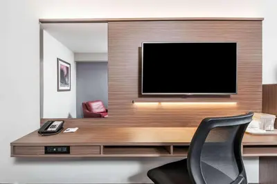 a room with a desk with a television and a chair at Microtel Inn & Suites by Wyndham Fort Saint John in Fort Saint John