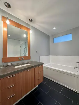 a bathroom with a sink and a tub and a mirror at The Grove B&B Mayne Island in Mayne Island