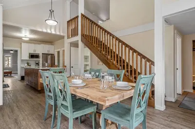 a dining room and kitchen with a wooden table and chairs at Dinos Last Post - Family Friendly 4 Bedrooms in Drumheller