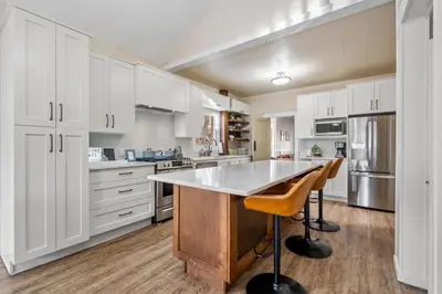 a kitchen with white cabinets and a large island at Dinos Last Post - Family Friendly 4 Bedrooms in Drumheller