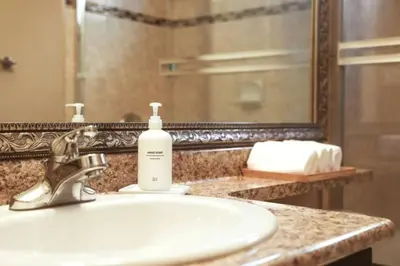 a bathroom sink with a bottle of soap on it at Close to YVR King Sized Private Entrance Suite in Richmond