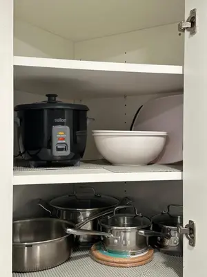 a kitchen shelf with pots and pans and a bowl at Juanus Cozy Cove in Edmonton
